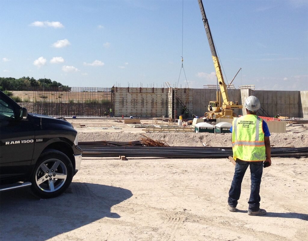 Guaranteed Waterproof technician inspecting commercial concrete waterproofing site in Utah